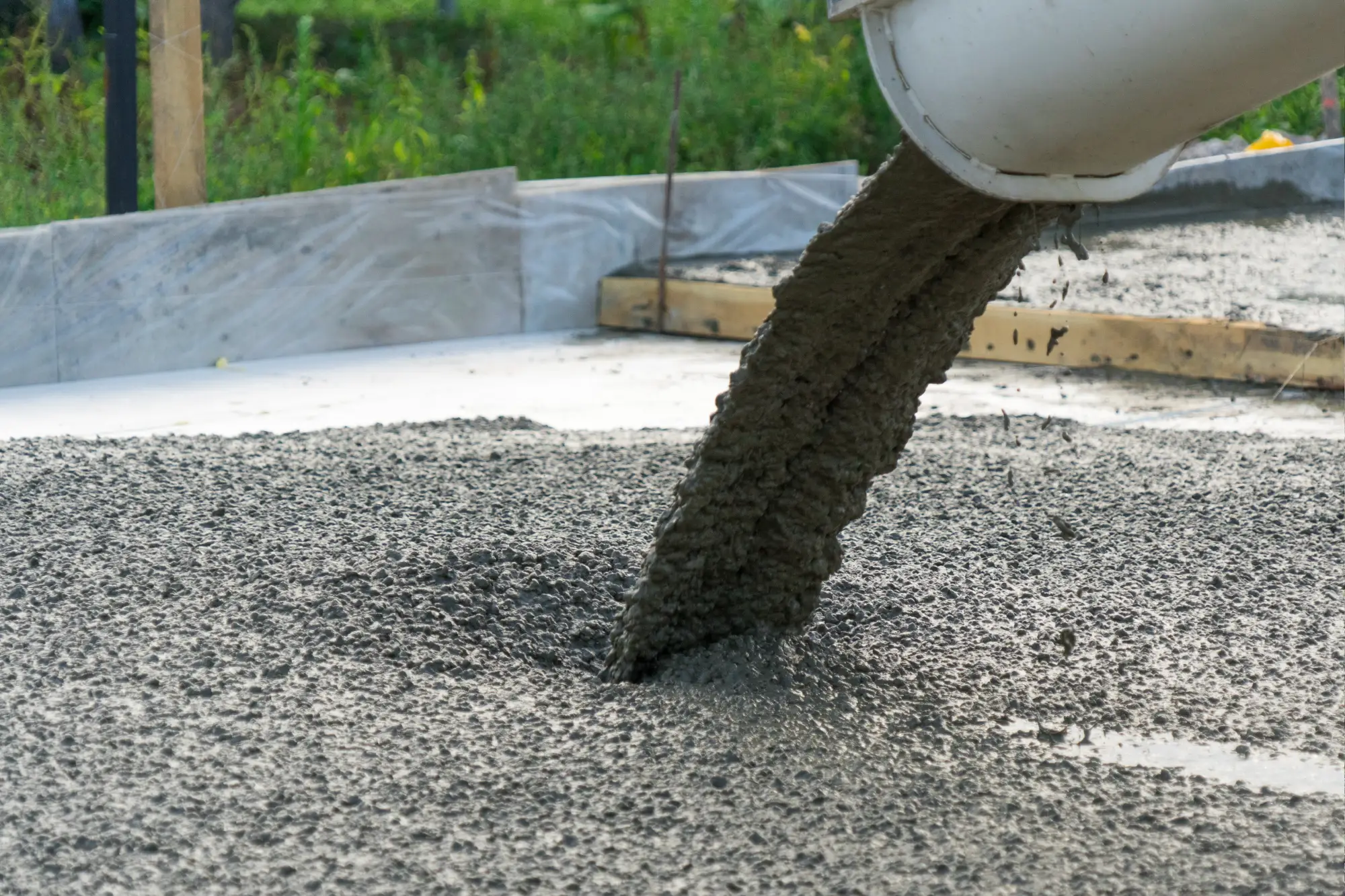 Concrete pouring into foundation.